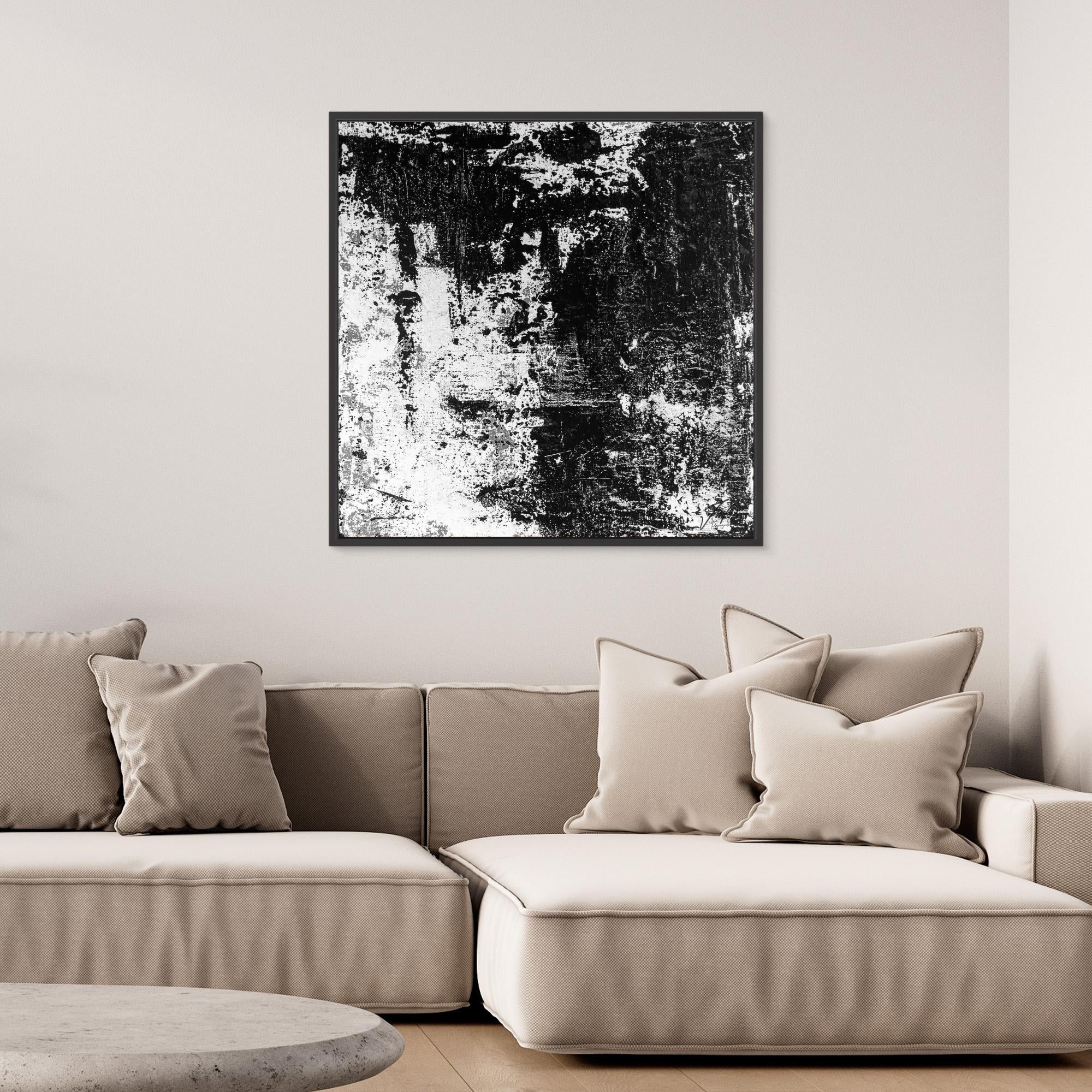 Beige sofa with decorative pillows and a black and white abstract painting on the wall.