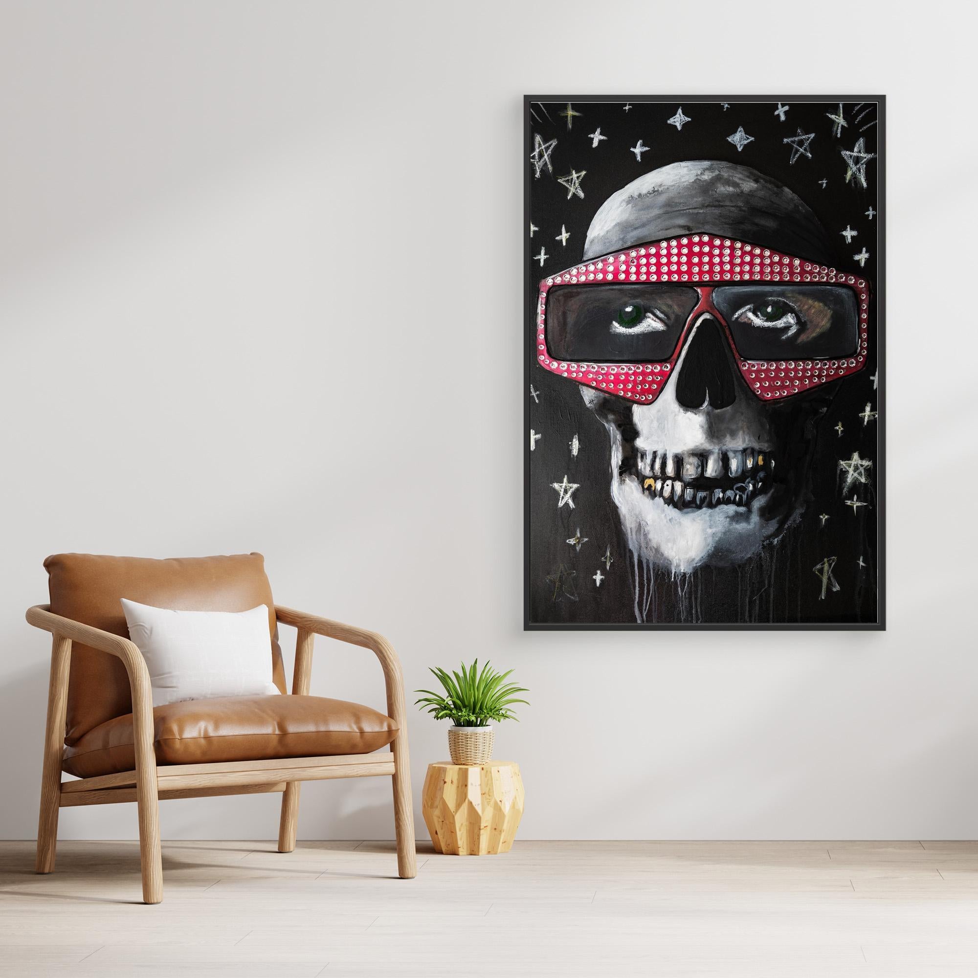 A canvas print of a painted skull wearing sunglasses with a black, white, and red color scheme, displayed in a room with a leather chair and a side table.