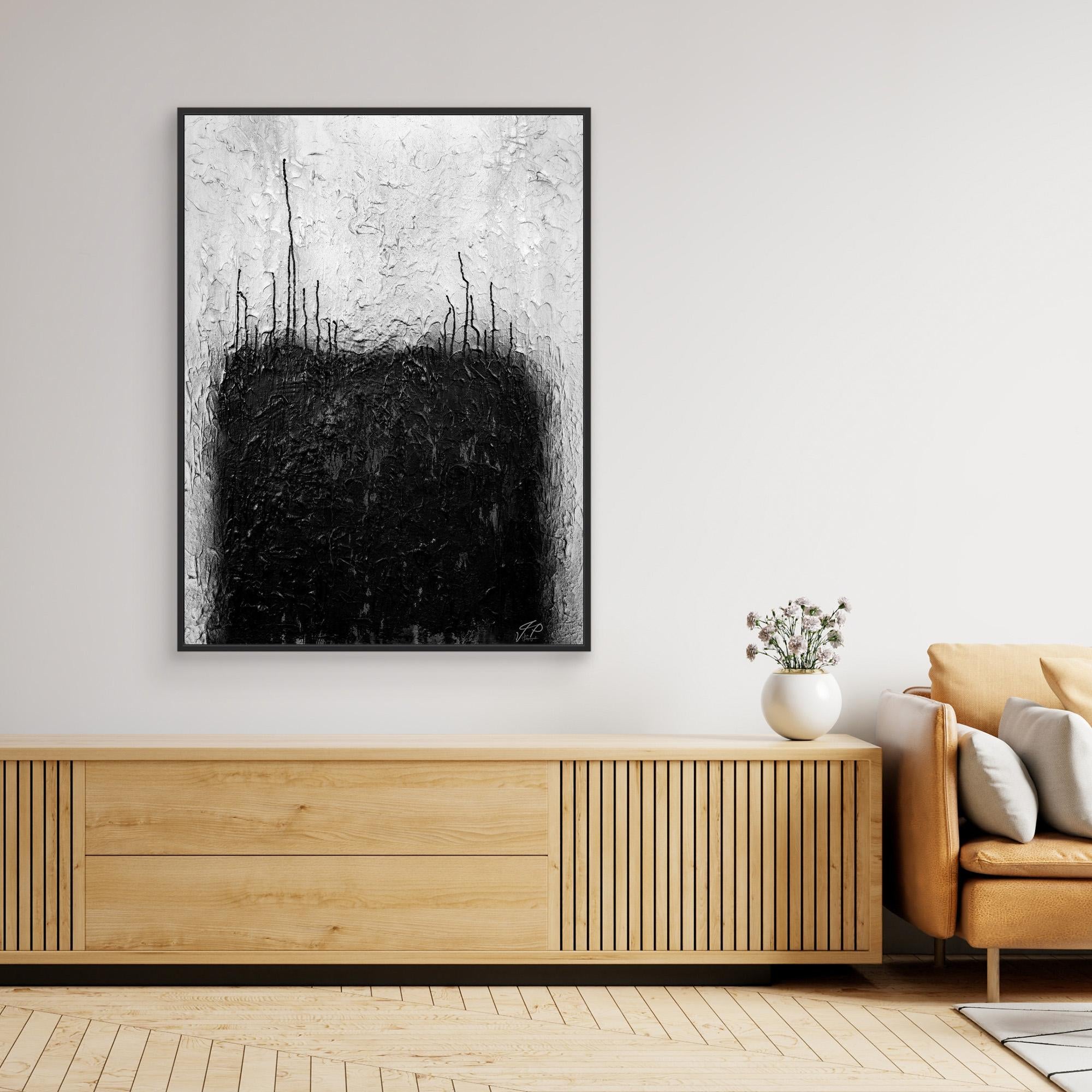 Black and white abstract painting above wooden console table, white vase with flowers, beige sofa.