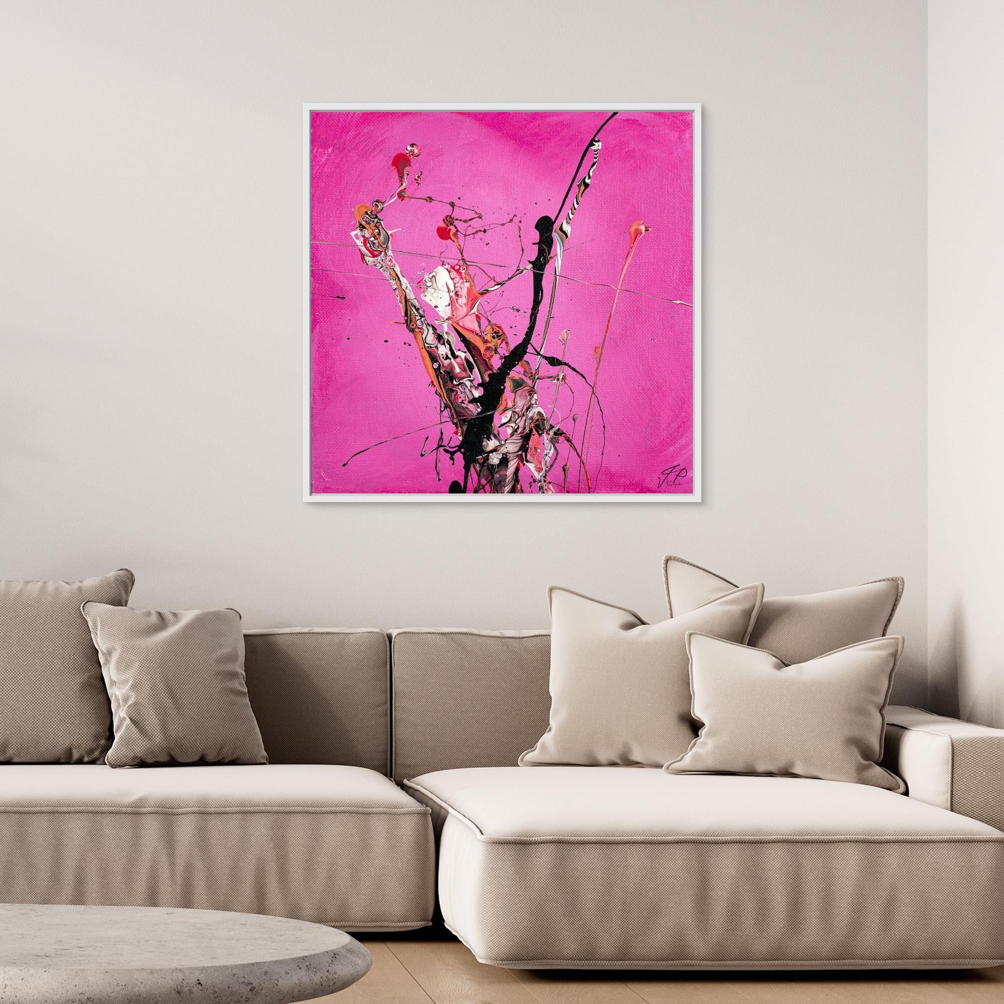 Abstract art with black, white, and pink splashes on a bright pink background above a beige sofa.
