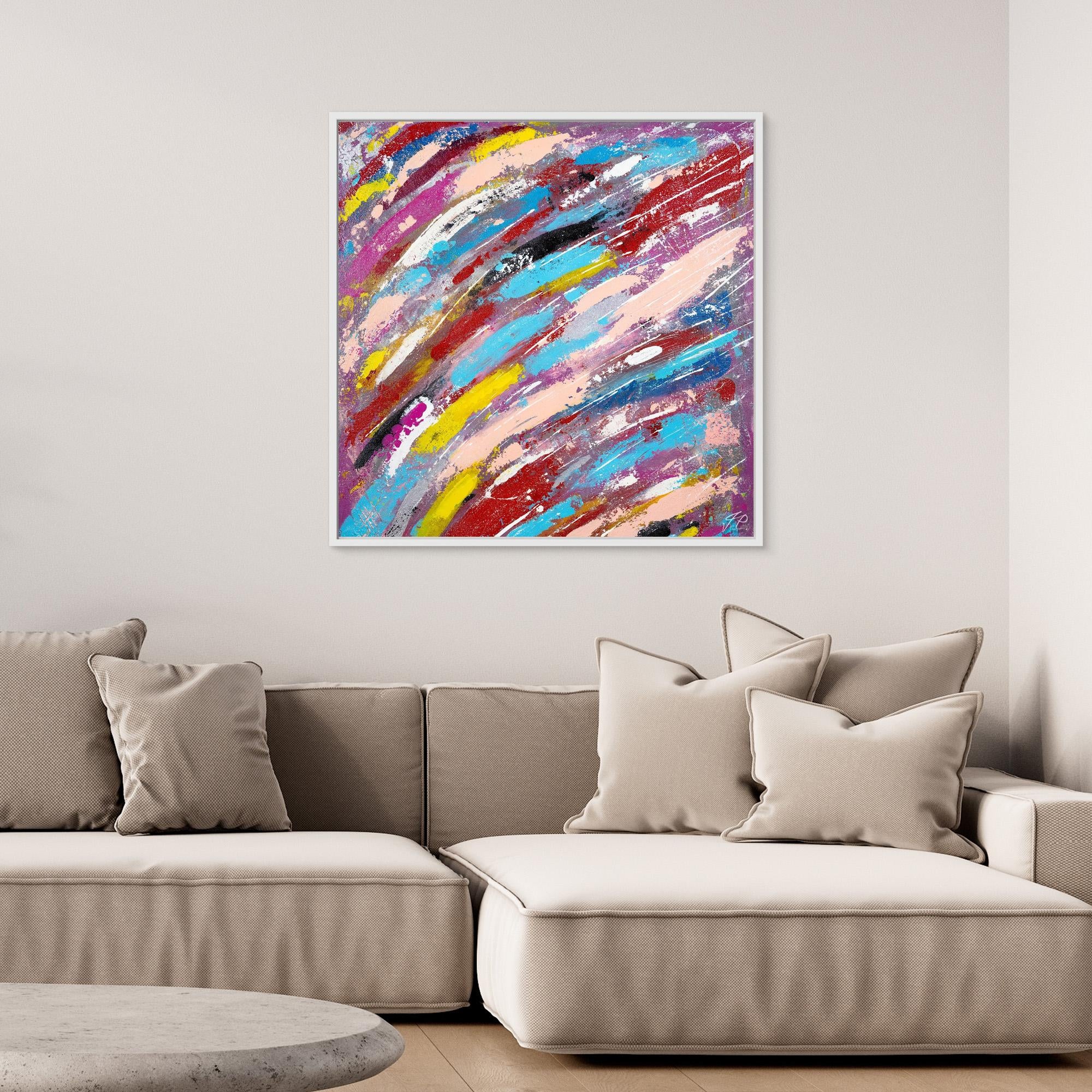 Colorful abstract painting with vibrant streaks of pink, yellow, blue and red above a beige sectional sofa.