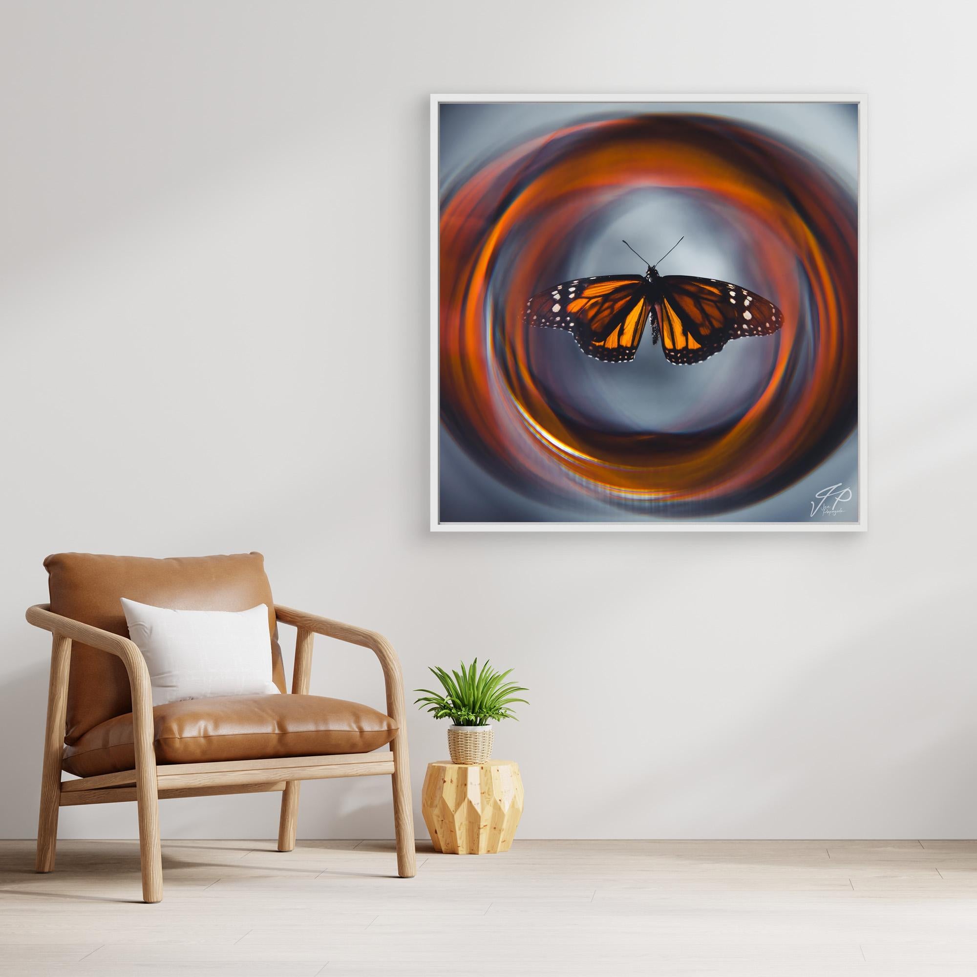 Framed monarch butterfly artwork with swirling orange background, leather chair with cushion, and geometric plant pot.