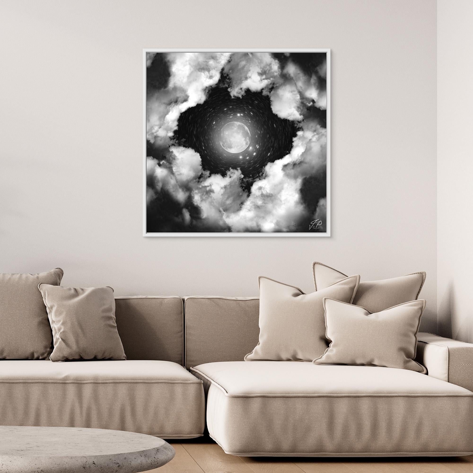 Glowing moon and clouds painting centered above a neutral sectional sofa with pillows.