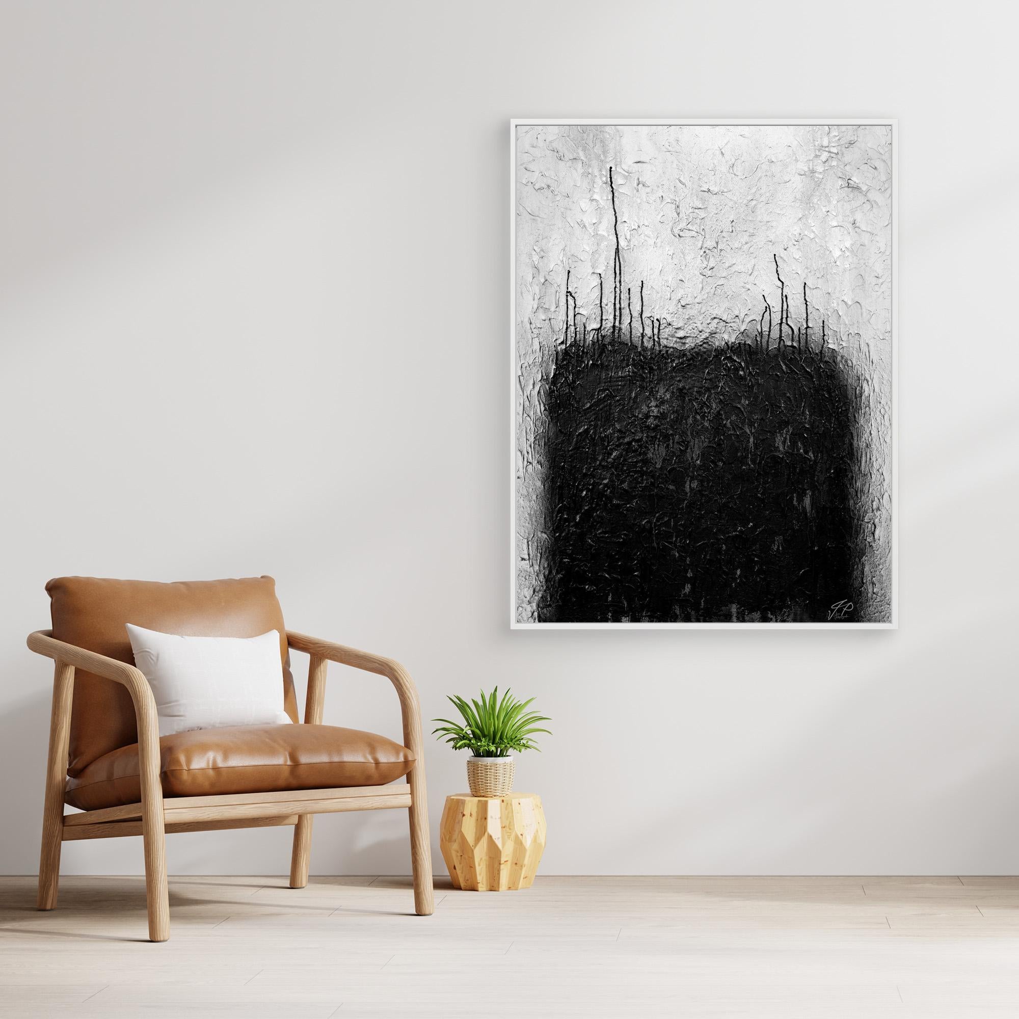 Black and white abstract painting above wooden console table, white vase with flowers, beige sofa.