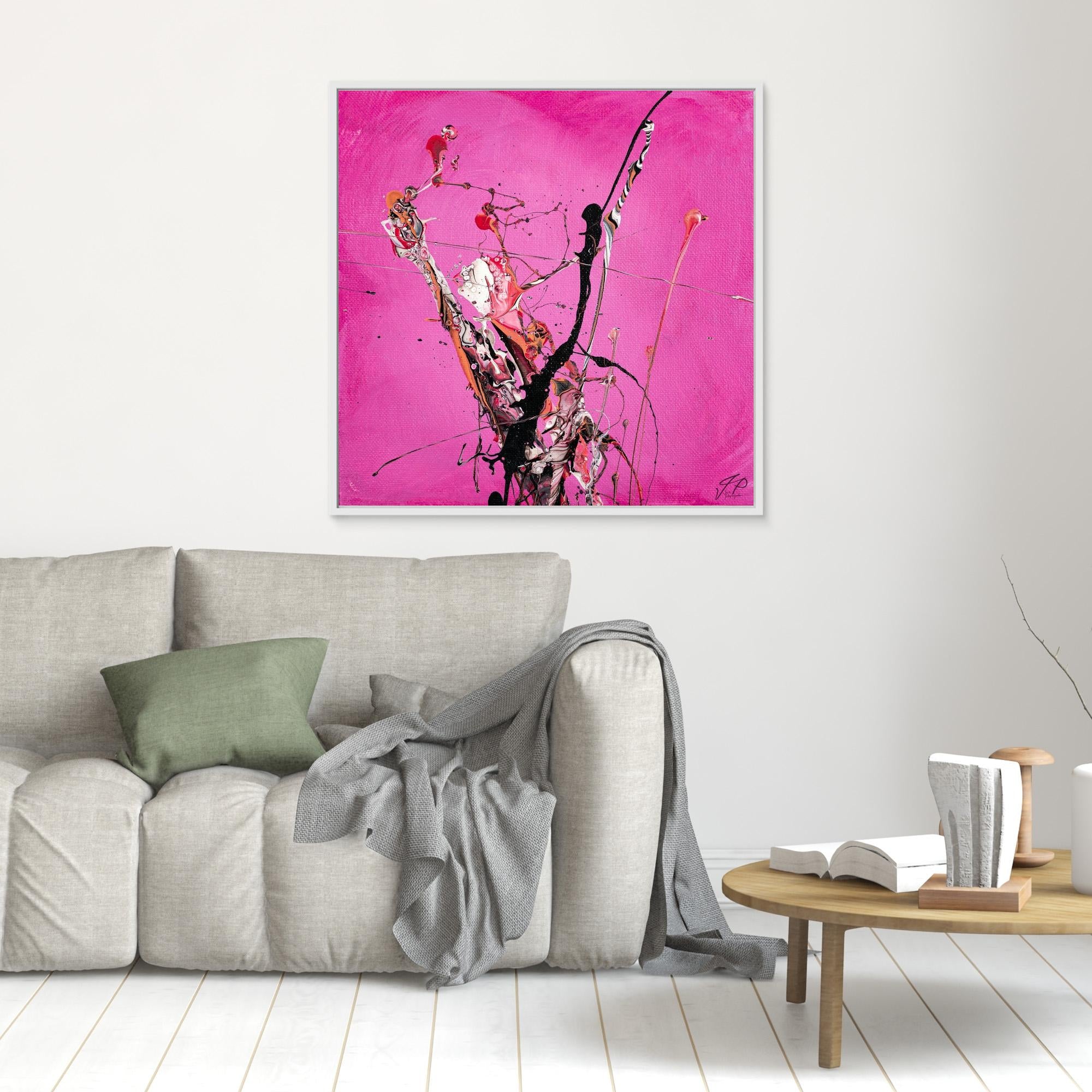Abstract art with black, white, and pink splashes on a bright pink background above a beige sofa.