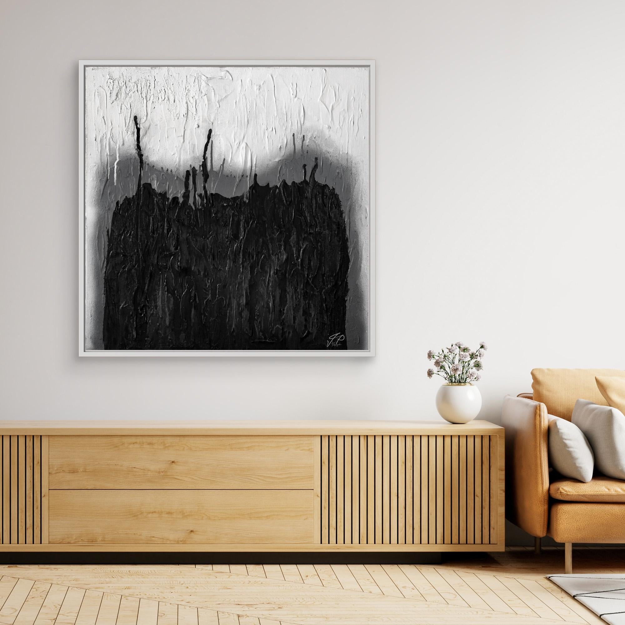 Large black and white textured abstract painting above a wooden console, with a beige armchair and floral vase.