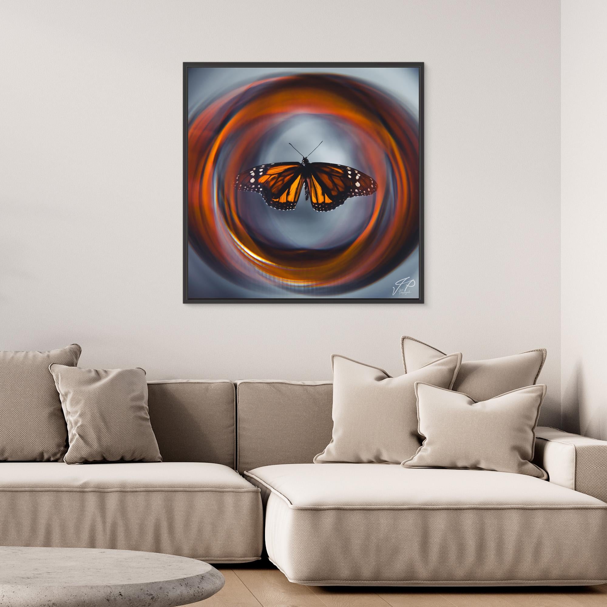 Framed monarch butterfly artwork with swirling orange background, leather chair with cushion, and geometric plant pot.