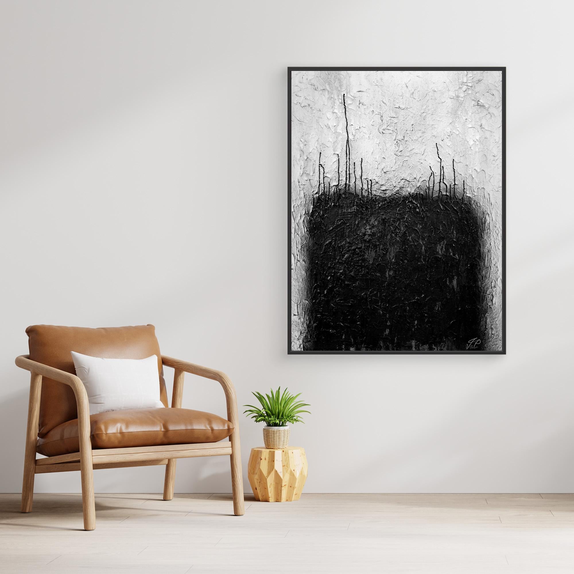 Black and white abstract painting above wooden console table, white vase with flowers, beige sofa.