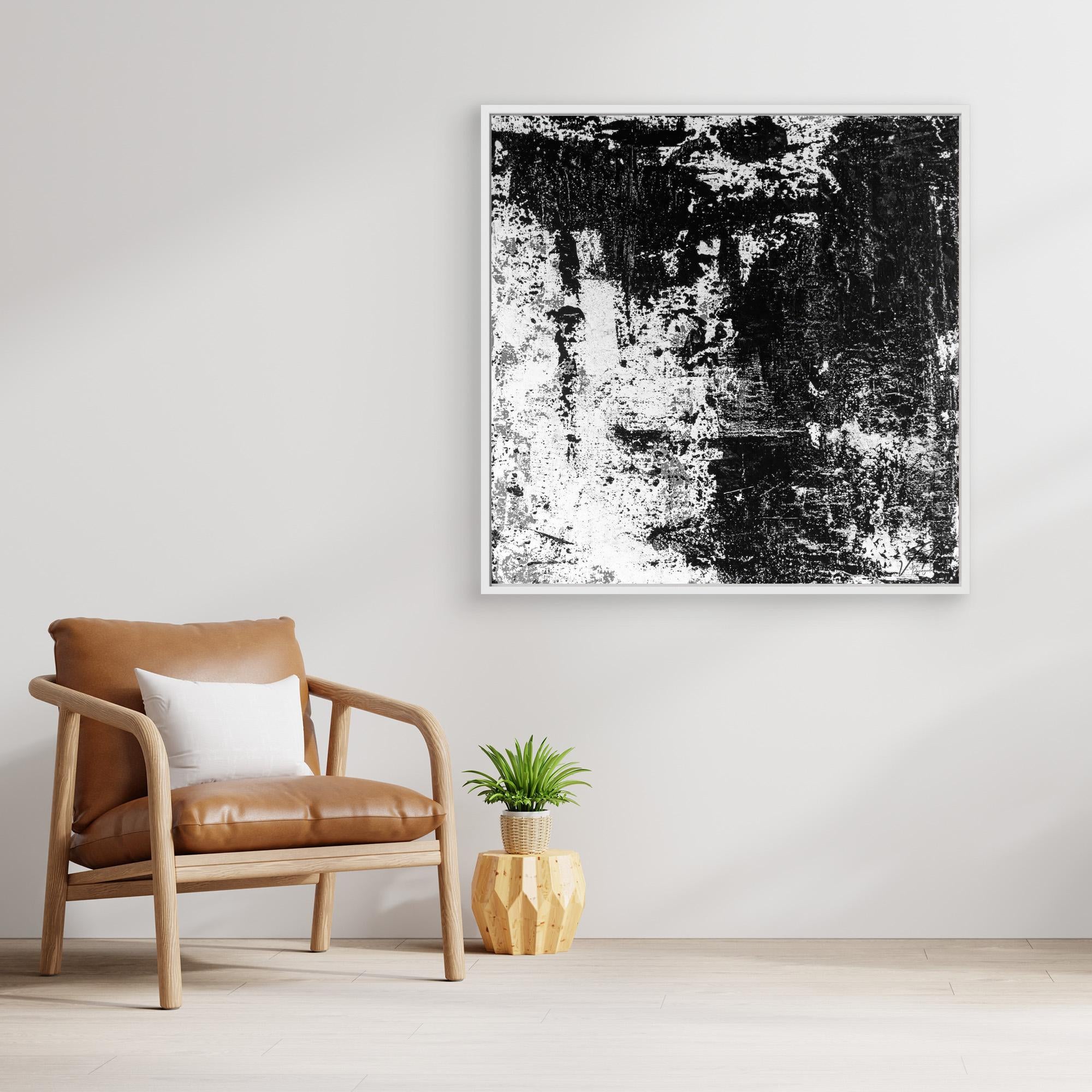 Modern interior with a brown armchair, white pillow, and abstract black and white art print of a painting on a light gray wall.